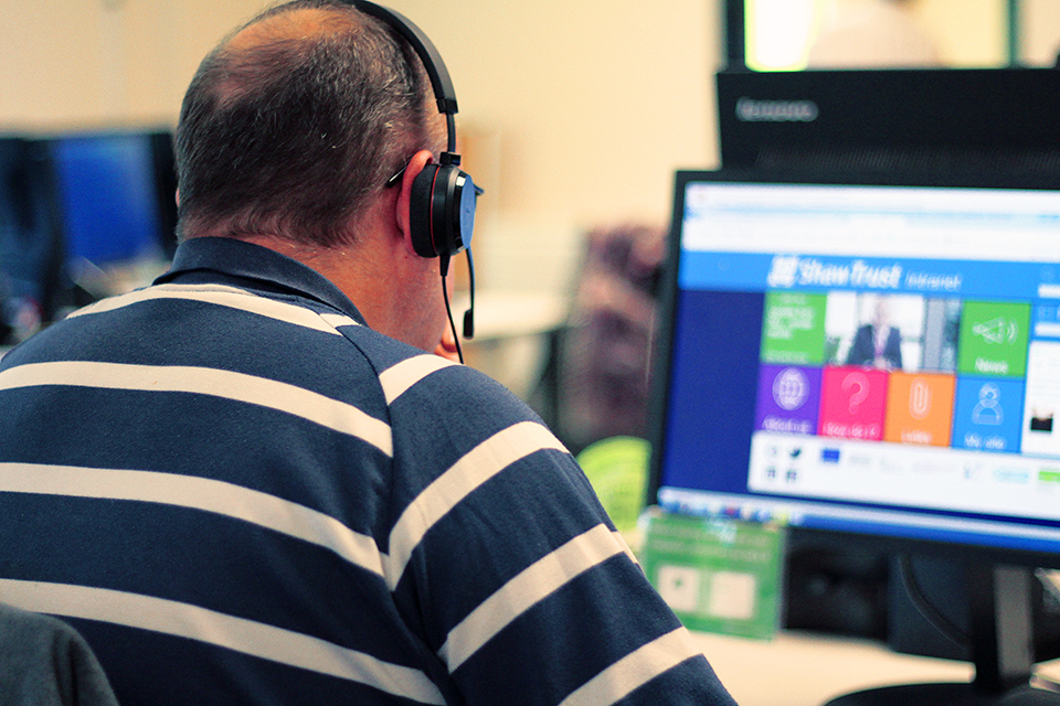 An Accessibility Assessor sat in front of his computer, wearing a headset